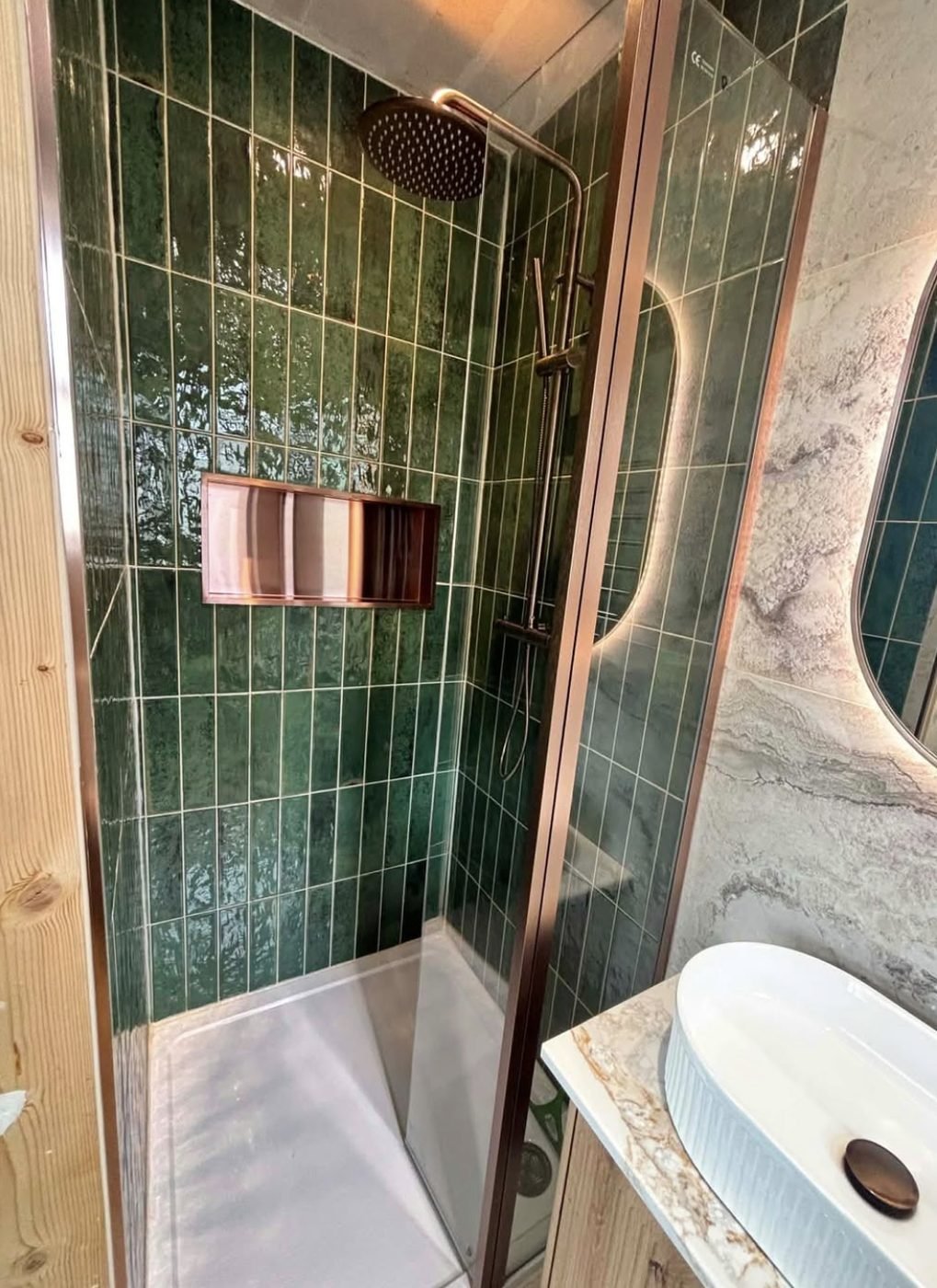 Green metro tiled shower enclosure with copper framed screen and rainfall shower