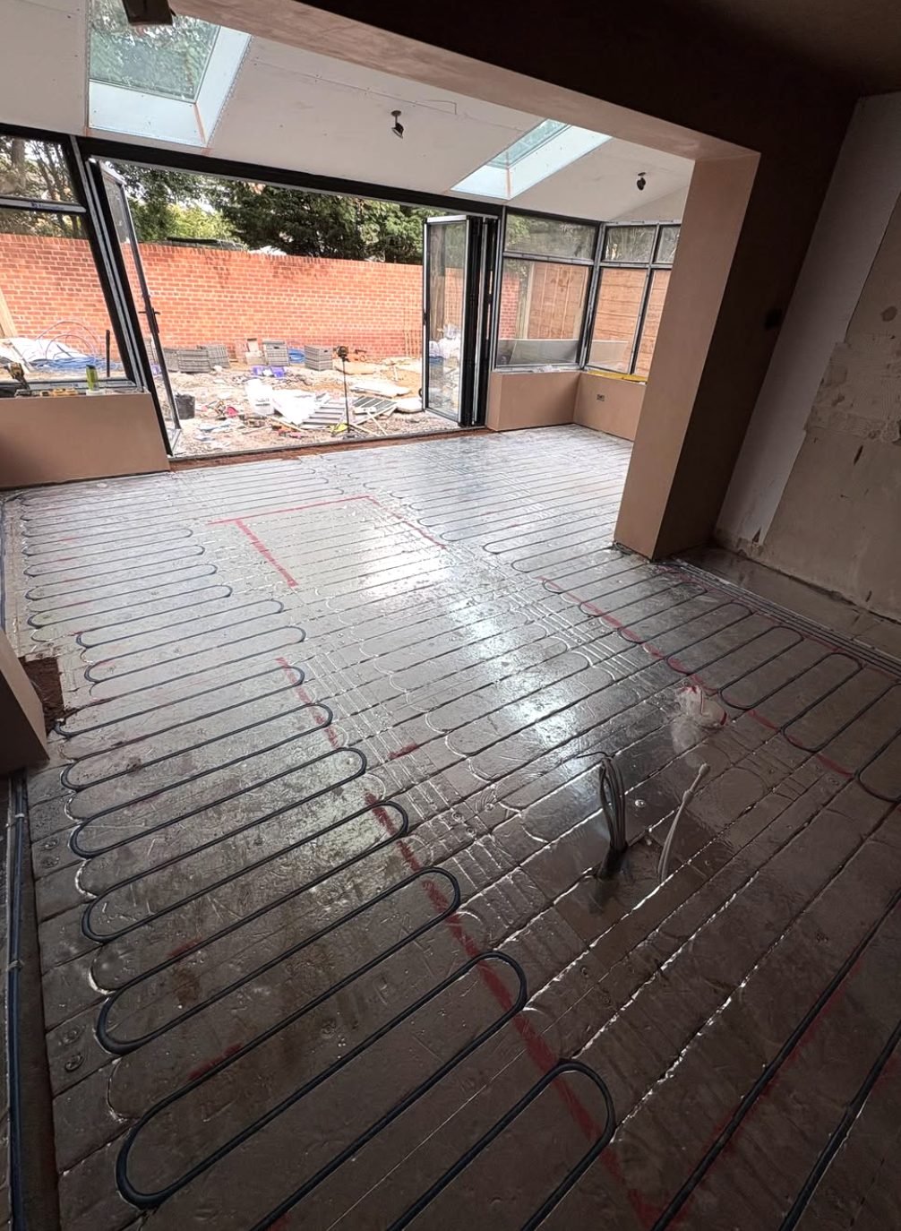 Wet underfloor heating pipework laid across an extension floor before screeding